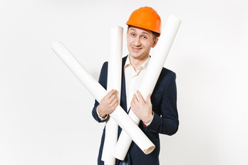 Young satisfied smiling businessman in dark suit, protective construction orange helmet holding blueprints plans isolated on white background. Male worker for advertisement. Business, working concept.