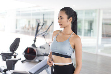 Fototapeta na wymiar Asian beautiful woman looking her body at gym. Sport and Reaction concept.