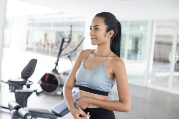 Asian beautiful woman looking her body at gym. Sport and Reaction concept.