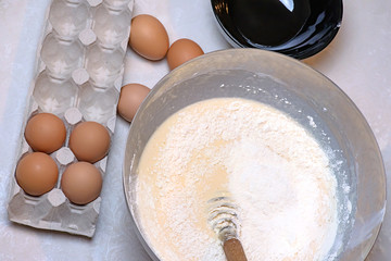 Kneading dough for pancakes. With flour and egg