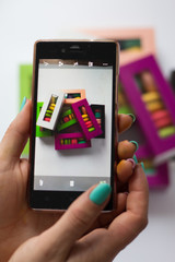 photo in the phone of macaroons in colored boxes