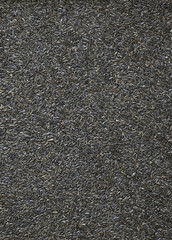 A uniform background of Nyjer seed from Ethiopia, a bird food desireable to finches, siskins and juncos.