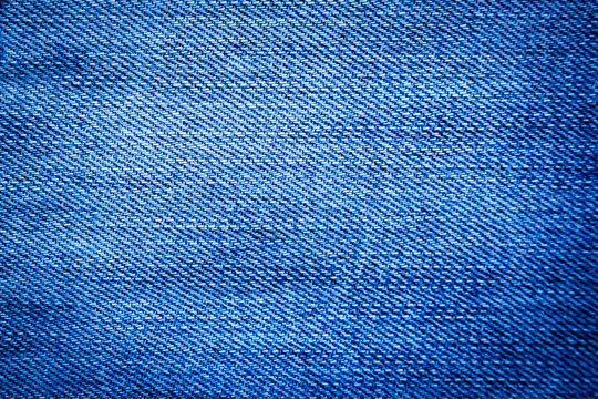 The image of textures of blue denim fabrics with vignetting for the background,