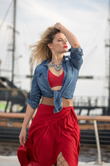 Beautiful woman in a red dress on a ship background.