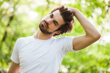 Young man is exercising. He is stretching his body.