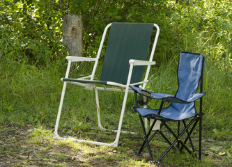 An adult and child foldable chair at a campsite
