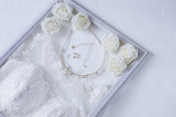 wedding dress, hoop, pearls on a gold chain, earrings, roses in a white frame - wedding background