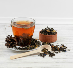 Cup of tea with tea leaves scattered.