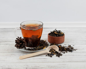 Cup of tea with tea leaves scattered.