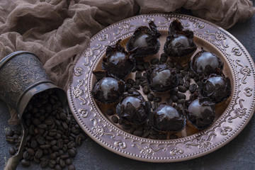 on a bronze plate a coffee dessert with chocolate and coffee beans