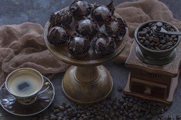 on the table a chocolate dessert, a cup of coffee and a coffee grinder