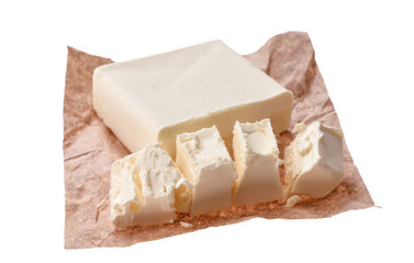 Creamy piece of butter on a saucer over food paper background