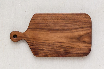 Handmade walnut wood cutting board on the linen