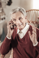 So happy. Joyful male person keeping smile on his face and wrinkling forehead while looking aside