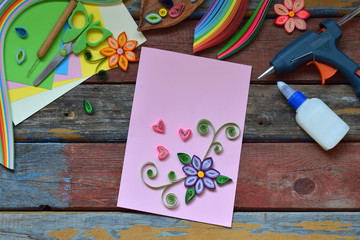 Quilling technique. Paper strips, flowers, scissors, elements. Handmade crafts on holiday theme: Birthday, Mother's Day, March 8, Wedding. Making decoration or greeting card. Children's DIY concept.
