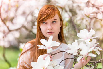 Ruda dziewczyna z magnoliami - obrazy, fototapety, plakaty