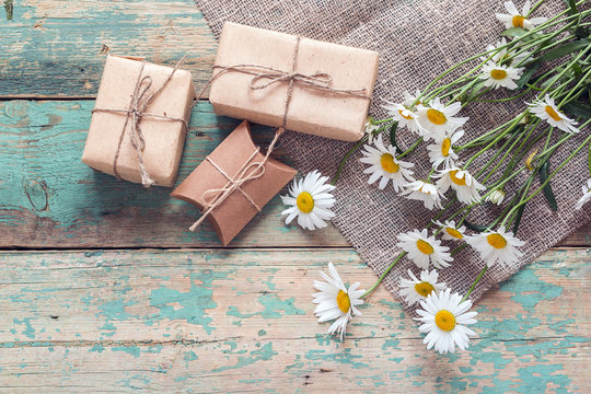 Rural background with daisies and gift boxes.