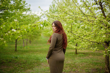 lovely girl in spring blossoming garden