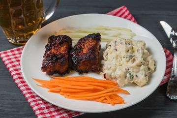 Pork ribs with American potato salad, carrot and celery. Beer snack