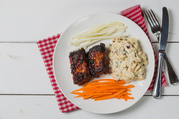 Pork ribs with American potato salad and carrot. The view from the top. Copy-space