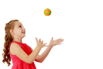 The little girl throws the ball up
