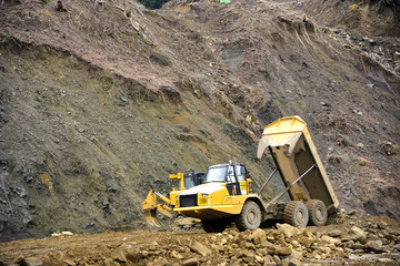 Heavy articulated dump truck work at a huge dam construction site
