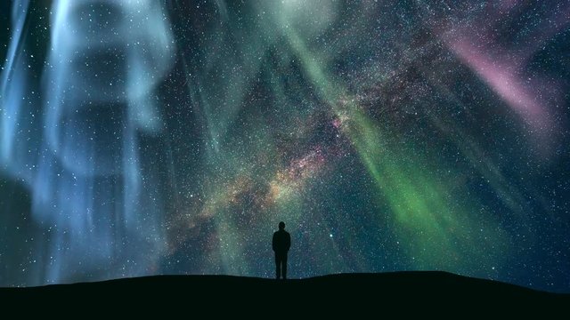 The man standing against the starry sky with the northern light. time lapse