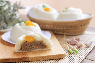 Chinese white steamed bun known as Dim Sum or salapao filled with minced pork seasoning decorate with hard boiled egg and coriander ready to serve for breakfast or lunch. Homemade food concept.