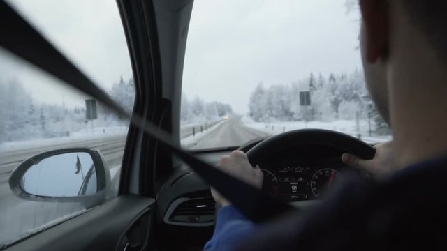 Man driving a car through the winter road