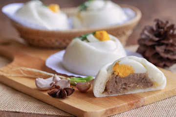 Chinese white steamed bun known as Dim Sum or salapao filled with minced pork seasoning decorate with hard boiled egg and coriander ready to serve for breakfast or lunch. Homemade food concept.