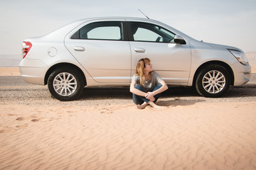 Girl have rest near car in desert