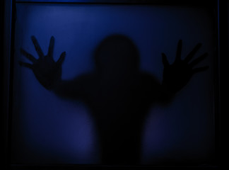 unfocused human silhouette behind in dark space in twilight 
