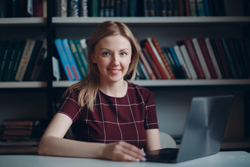 Young beautiful blond student girl with laptop close up portrait