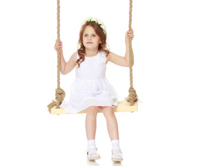 Little girl swinging on a swing