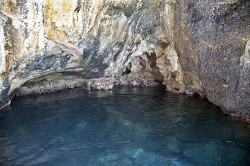 Interior of a natural sea cave, Cilento, Italy. The reddish sediments are due to the zinc oxide.