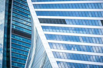 Bottom view of modern skyscrapers in business district against blue sky