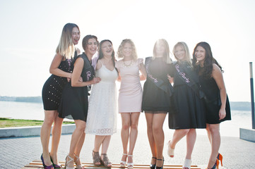 Obraz premium Group of 7 girls wear on black and 2 brides at hen party.