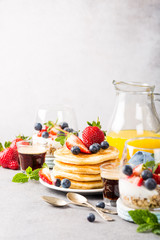 Breakfast background with fresh pancakes and berries on light gray concrete table. Healthy food concept with copy space. - obrazy, fototapety, plakaty