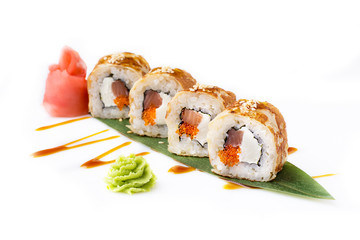 Fresh and original sushi rolls with smoked tuna and Philadelphia cheese in an omelette laid out on a banana leaf. Isolated. Sushi roll on a white background.