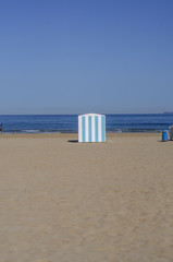 Beach scene with striped stand 