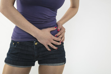 A young woman is struggling with pain, isolated on background