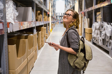 Woman looking for goods in the self-service warehouse