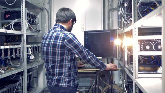 Backside view of an adult man working in a mining rig