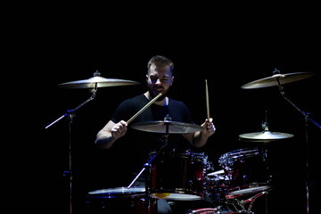 music, people, musical instruments and entertainment concept - male musician with drumsticks...