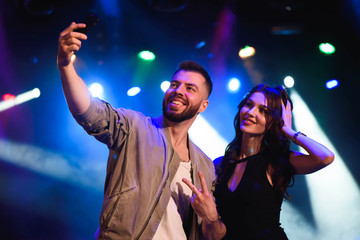 Image of happy young couple having fun at disco. Young man and woman enjoying a party.