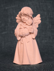 Fototapeta na wymiar A wooden sculpture of a small angel with a cat on his hands. It was bought in a souvenir shop in Oberammergau (Germany). Russia, March, 2018.