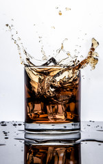 Splash of whiskey with ice isolated on white