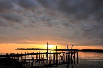 silhouette of a wooden jetty at sunset, vacation by the sea