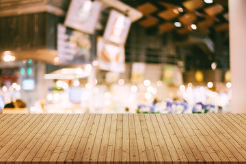 image of wooden table in front of abstract blurred background of resturant lights