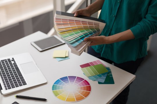 Female graphic designer holding color shade cards